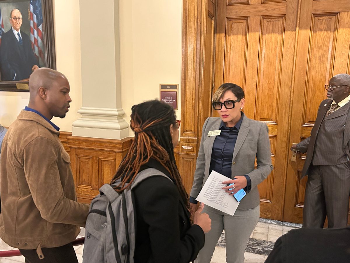 Students and program staff meeting with a state representative outside the House of Representatives chambers during a career and technical education visit