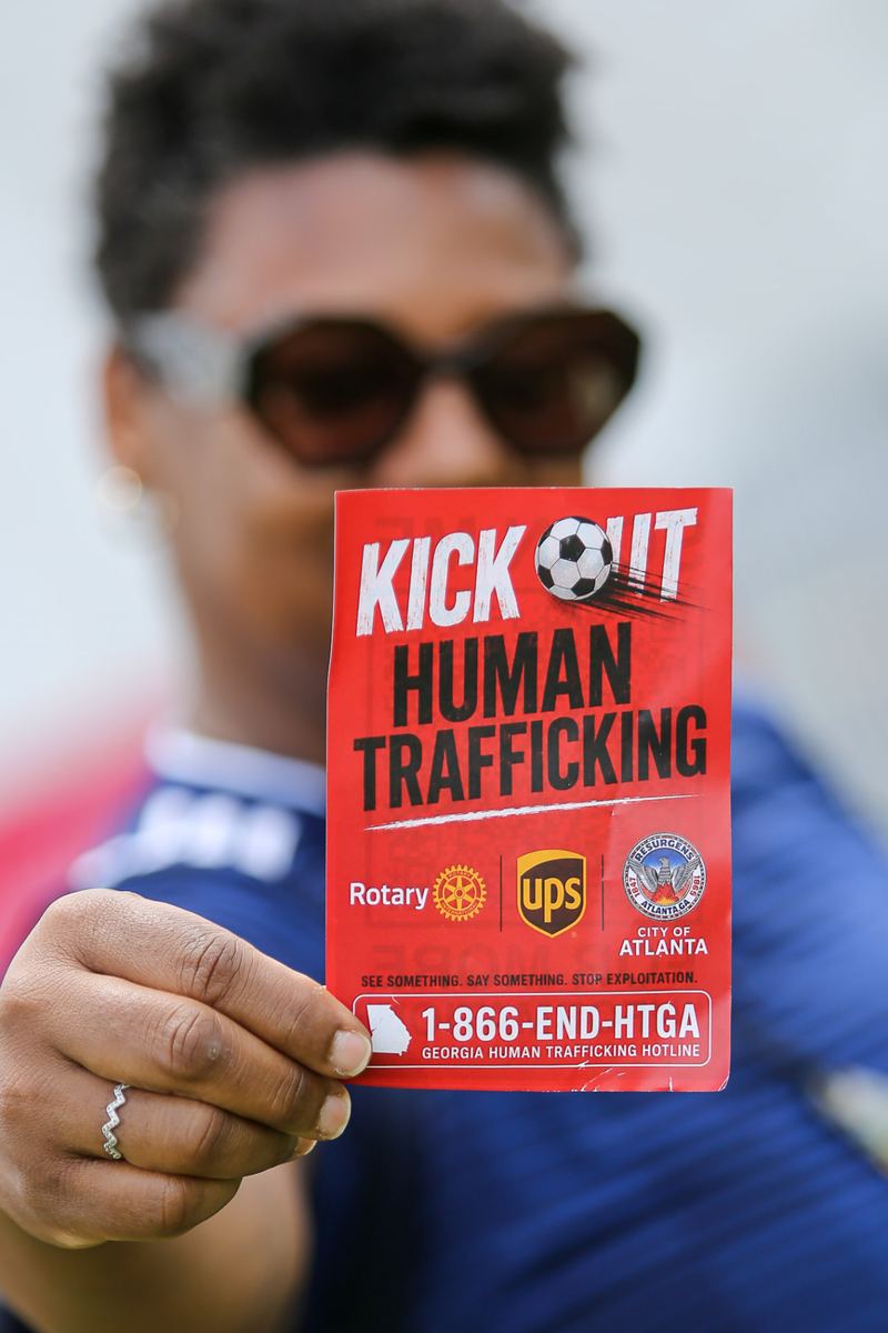 A participant holding an anti-human-trafficking awareness card at a community outreach event